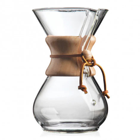 Clear Chemex glass coffee maker with wooden collar on a white background