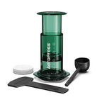 Green Aeropress coffee maker with components on a white background