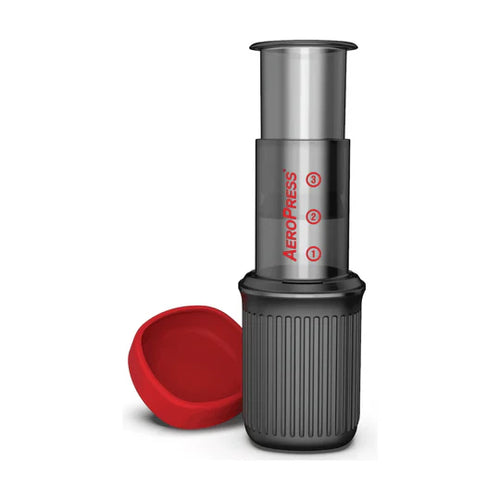 AeroPress coffee maker with a red lid on a white background
